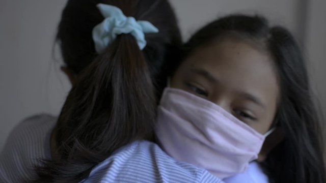 Mother and her daughter hugging each other and wearing protective mask during COVIC 19 outbreak situation. Corona virus protection. Healthy and safety life concept. Expression of love.