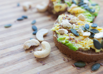 whole grain toast with avocado and pumpkin and flax seeds, cashew nuts