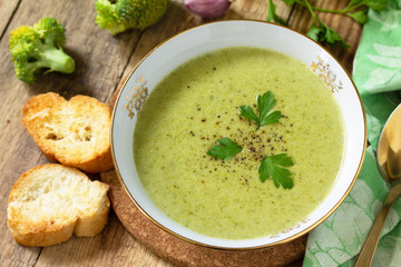 Vegetarian dish. Delicious broccoli cream soup served with garlic croutons on a rustic table.