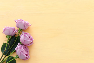 summer bouquet of pink roses flowers over wooden pastel background. top view, flat lay