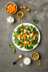 Cooking salad with pumpkin and basil. Ingredients on grey background top-down