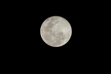 view of full moon at night rise up in dark sky background.