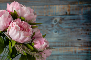 bouquet of pink peonies on blue wooden background.