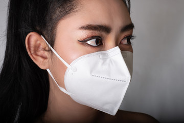 Close up of a asia woman putting on a respirator N95 mask to protect from airborne respiratory...