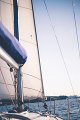 White cloth fabric, masts and ropes close-up on sail of tri-yacht or yacht sailing boat