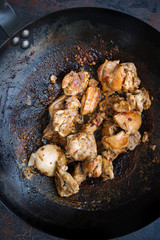 Chicken in a wok pan, Cooking process, Asian cuisine on dark background