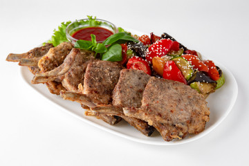 Rack of lamb, or rabbit shoulder blade, pork ribs with grilled vegetables. Banquet festive dishes. Gourmet restaurant menu. White background.