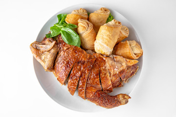 Baked stuffed duck in a cut with pancakes. Banquet festive dishes. Gourmet restaurant menu. White background.