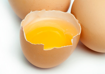 Tree whole eggs and another broken in half raw egg