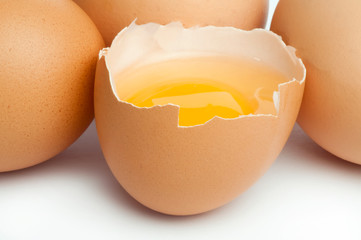 Tree whole eggs and another broken in half raw egg