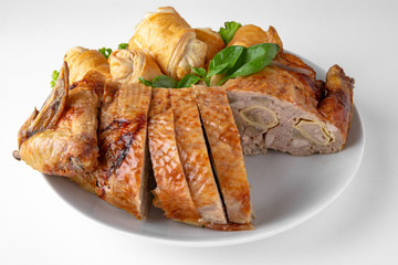 Baked stuffed duck in a cut with pancakes. Banquet festive dishes. Gourmet restaurant menu. White background.