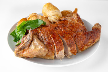 Baked stuffed duck in a cut with pancakes. Banquet festive dishes. Gourmet restaurant menu. White background.
