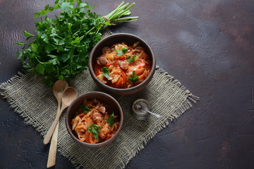 Cabbage stew with grilled sausage in tomato sauce - traditional dish of German, Polish or Russian cuisine