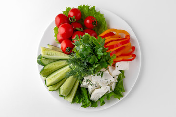 Appetizer of fresh vegetables and homemade cheese with herbs. Banquet festive dishes. Gourmet restaurant menu. White background.