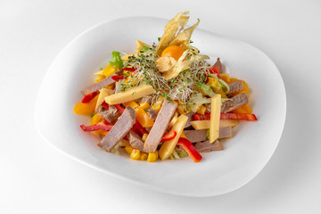 Salad of vegetables, meat and cheese with sauces. Banquet festive dishes. Gourmet restaurant menu. White background.