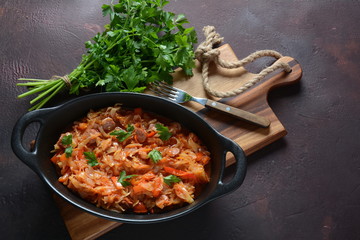 Cabbage stew with grilled sausage in tomato sauce - traditional dish of German, Polish or Russian cuisine