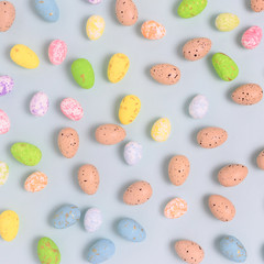 Pattern made of colorful easter eggs on a blue pastel background. Holiday creative concept.