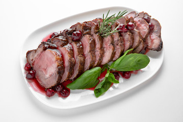 Sliced pork or beef tenderloin baked in cherry sauce. Banquet festive dishes. Gourmet restaurant menu. White background.