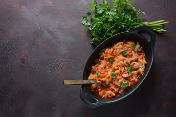 Cabbage stew with grilled sausage in tomato sauce - traditional dish of German, Polish or Russian cuisine