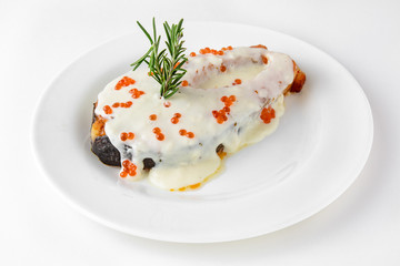 Baked salmon filet in a delicate creamy sauce with red caviar and rosemary. Banquet festive dishes. Gourmet restaurant menu. White background.