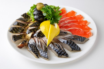 Plate with appetizer of fish and seafood. Sliced salted fish fillet. Smoked herring, salmon, perch,...
