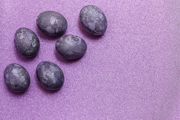 Eggs with marble stone effect painted with natural dye carcade flower on lilac sparkling background