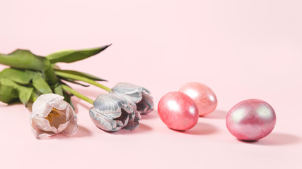 Easter eggs and flowers on a pink background.