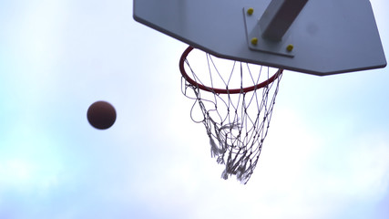 Basketball flies into the basket against the sky