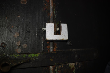 Steel lock hanging on the door of an old garage in the dark, copy space