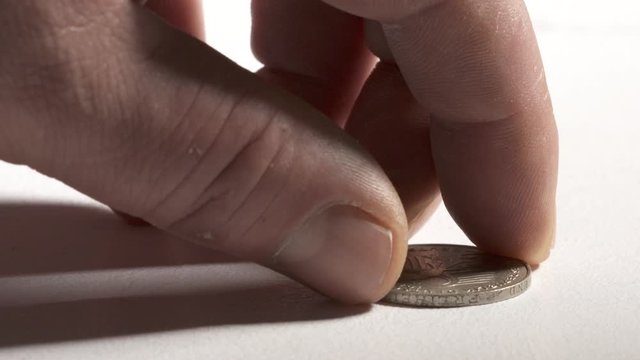 Hand taking 2 Deutsche Marks coin from desk obverse side showing eagle, emblem of Germany.