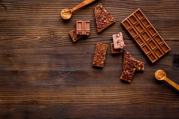 Homemade chocolate. Bars and broken pieces on wooden table frame copy space