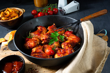 Spicy chicken wings in honey with potato wedges