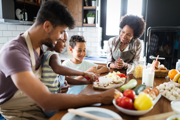 Happy family in the kitchen having fun and cooking together. Healthy food at home.