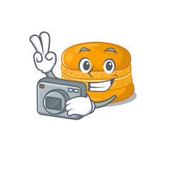 Orange macaron mascot design as a professional photographer with a camera