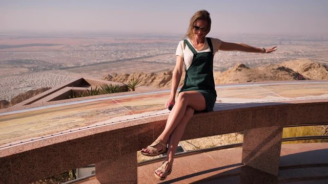 Happy girl posing on top near the city of Al Ain. United Arab Emirates.