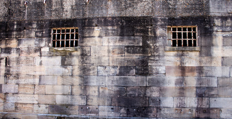 Historical sandstone convict built brick prison building, windows rusting security grill