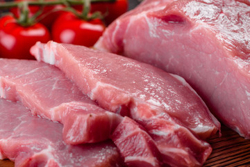 Fresh pieces pork ready to cook on a dark background in the kitchen