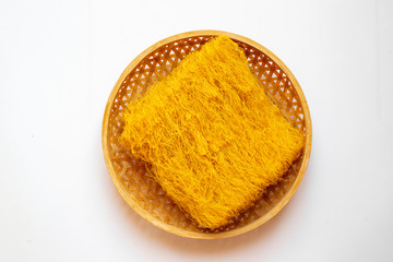 Rice noodles made with carrot juice on white background.