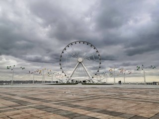 ferris wheel on the embankment of Baku against a gloomy sky