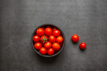 Top view of fresh red cherry tomatoes (grape tomatoes ) on dark background. Some cherry tomatoes is cutted