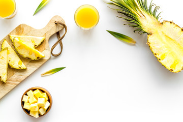 Make pineapple juice. Glasses near sliced fruits on white background top-down copy space frame