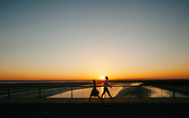Couple walking next to a river during sunset