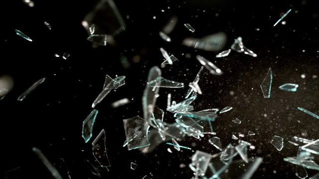 Profile view of Glass breaking in slow motion on black background