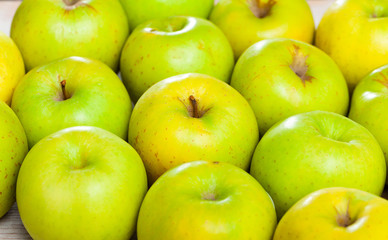 Many of ripe green apples on the wooden table