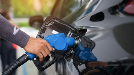 Fototapeta na wymiar Pumping gas at gas pump. Closeup of man pumping gasoline fuel in car at gas station.