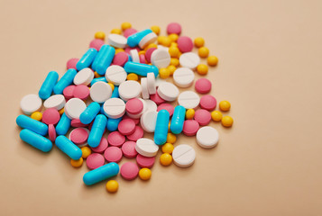 Assorted pharmaceutical medicine pills, tablets and capsules on beige background. Heap of various pills. Coronovirus, quarantine, epidemic, pandemic, flu, cold,illness. Medicine concept and health