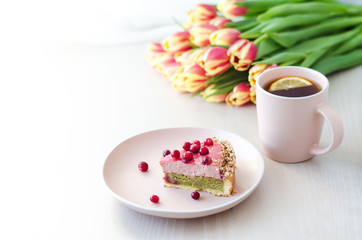 breakfast, holiday, morning with flowers tulips, cake, tea, coffee in pink mug on light background. women’s, mother’s, Valentine's Day, birthday. copy space, soft focus