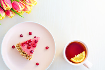 top view for breakfast, morning with flowers tulips, cake, tea in pink mug on white background. womens, mothers, Valentines Day, birthday. copy space, soft focus