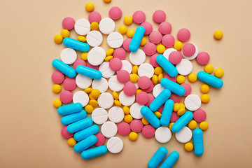 Assorted pharmaceutical medicine pills, tablets and capsules on beige background. Heap of various pills. Coronovirus, quarantine, epidemic, pandemic, flu, cold,illness. Medicine concept and health