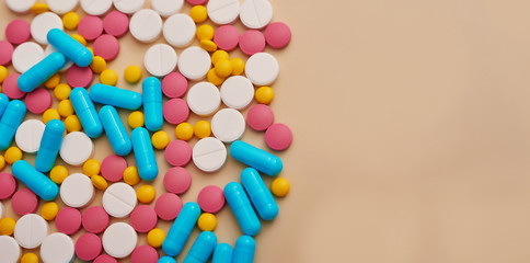 Assorted pharmaceutical medicine pills, tablets and capsules on beige background. Heap of various pills. Coronovirus, quarantine, epidemic, pandemic, flu, cold,illness. Medicine concept and health